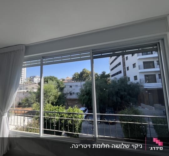 חלון נקי עם וילון לבן ונוף חיצוני
